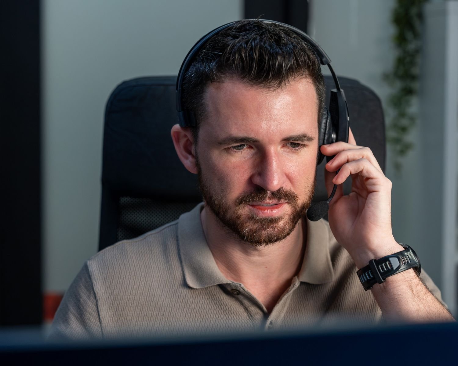 A SolusGuard monitoring agent wearing a headset, working an alert at their station